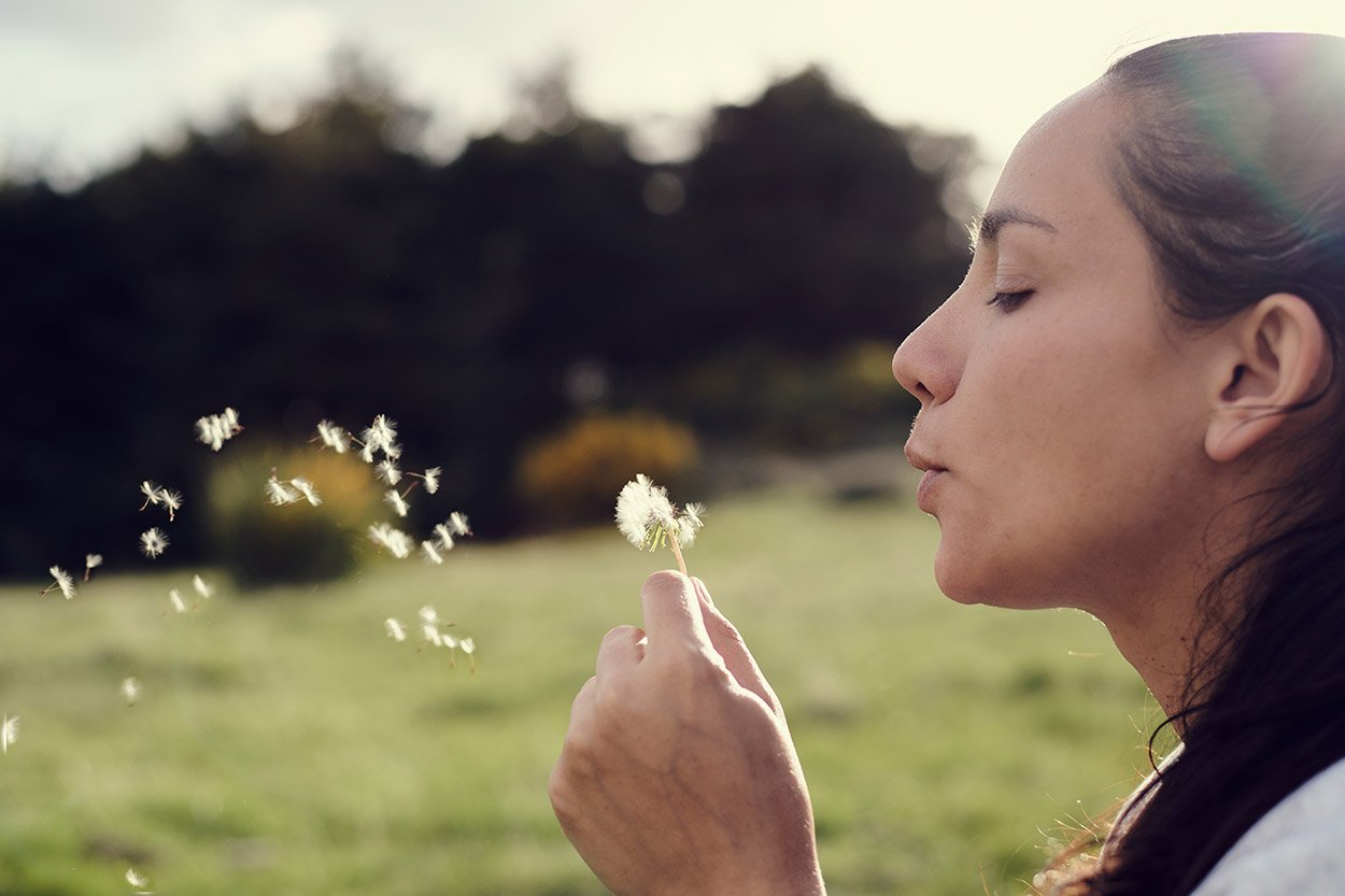 Native American woman blowing dandelion seeds